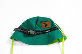 Green bucket hat with a brown label and black strap on a white background