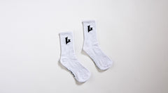 Pair of white socks with black logo on a light gray background