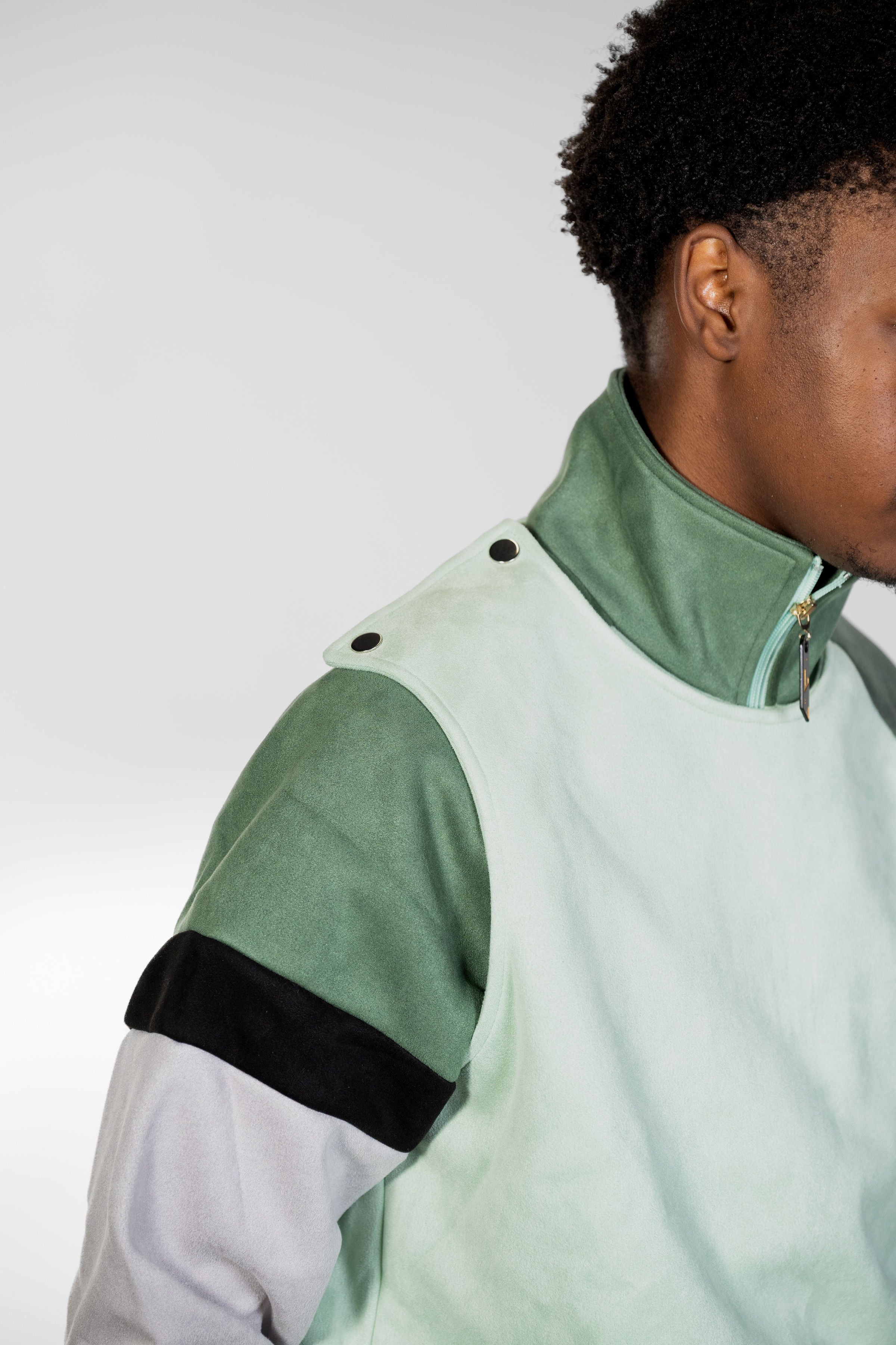 Person wearing a green and gray jacket with a white background