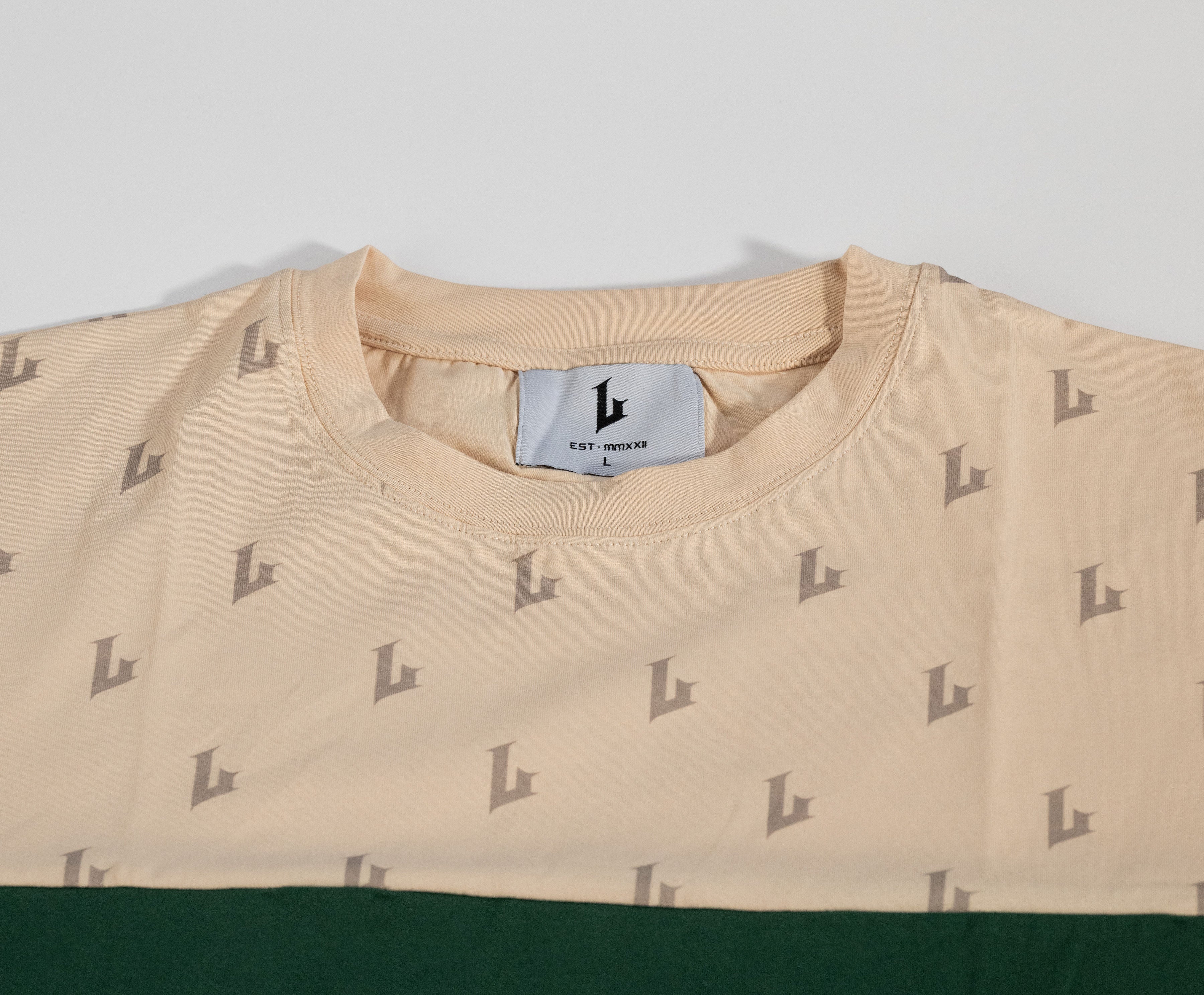 Beige sweatshirt with a pattern and brand label on a light gray background