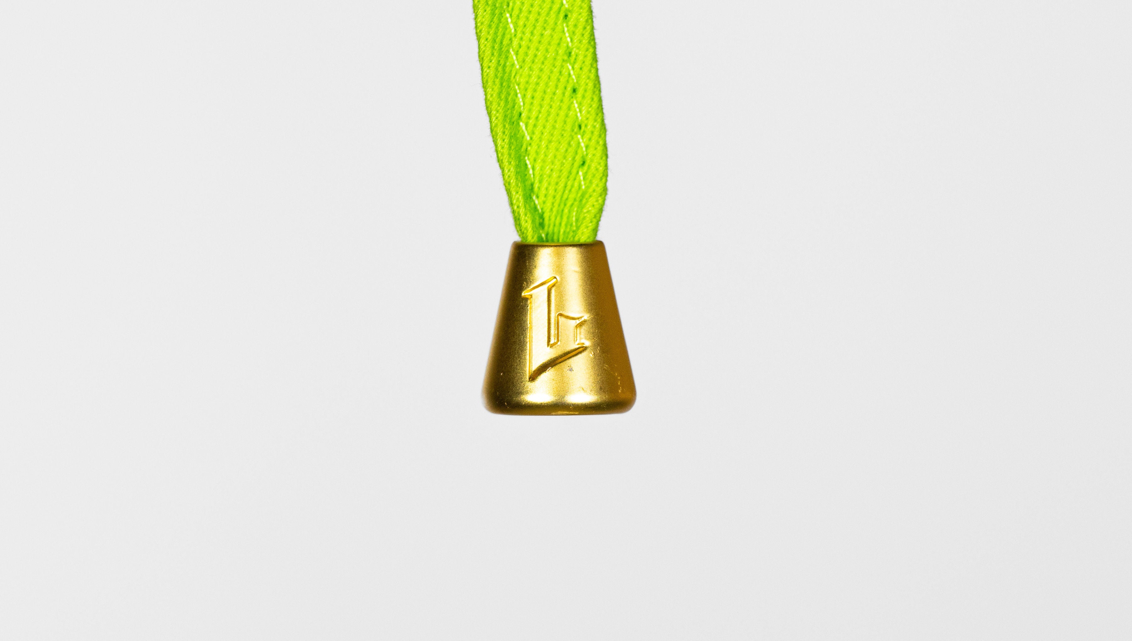Gold bell with a green rope on a white background