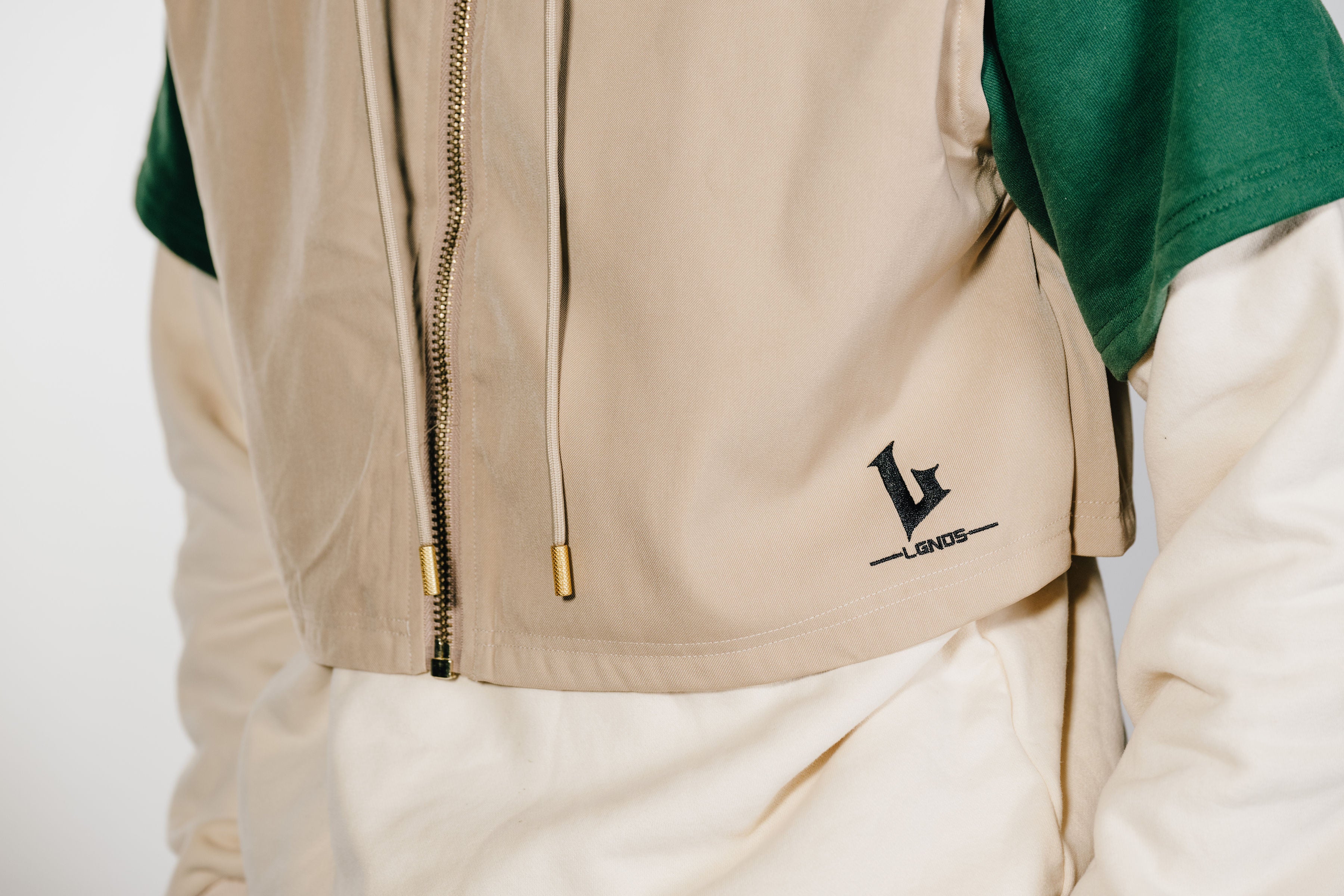 Beige jacket with a zipper and visible brand logo on a white background