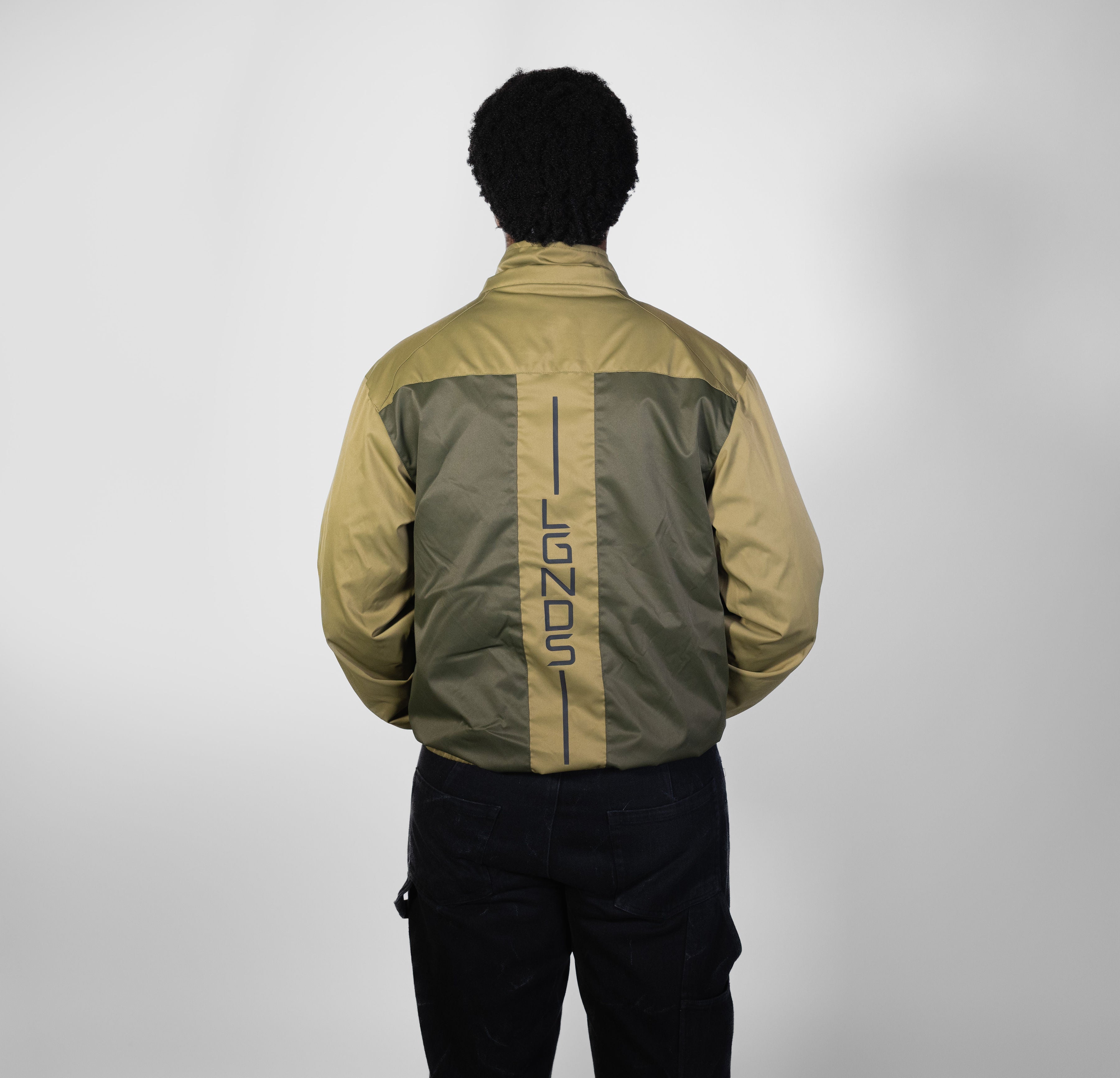 Person wearing a green and beige jacket with 'ILGNS' branding on a white background