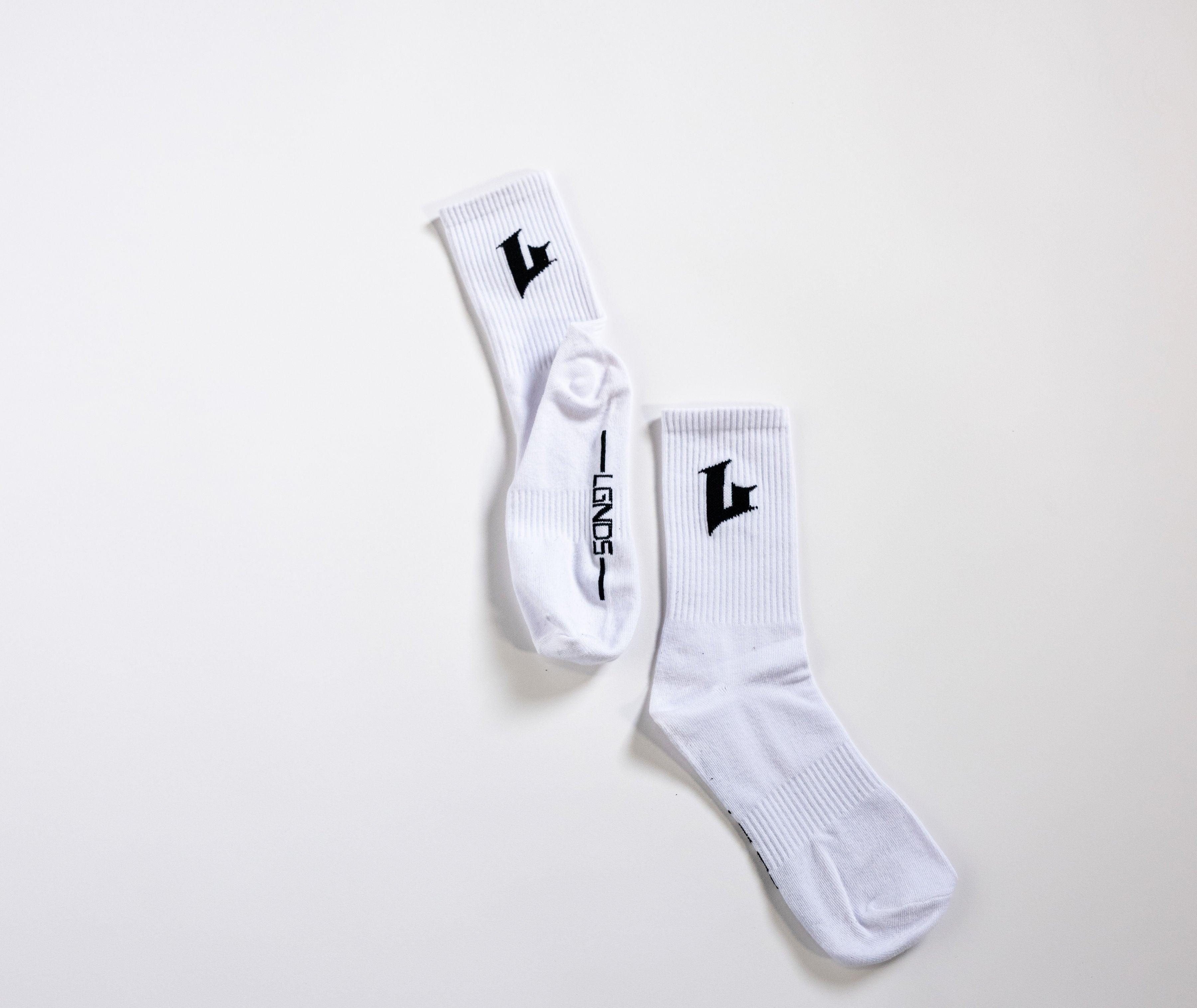 Two white socks with black logo on a light gray background