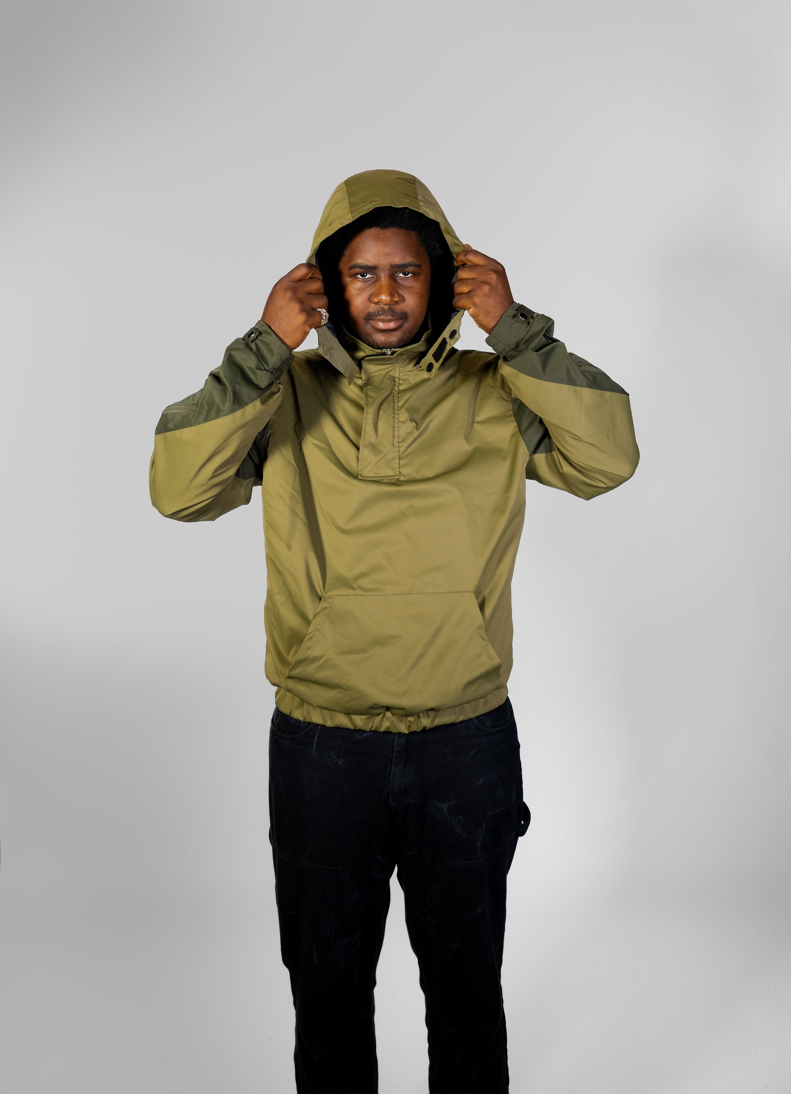 Person wearing a green raincoat against a white background